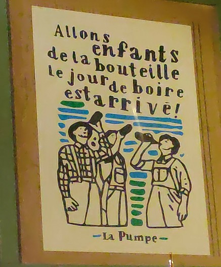 A poster hanging at the pub wall reading (in French):
Allons enfants
de la bouteille
le jour de boire
est arrive!
–La Pumpe–